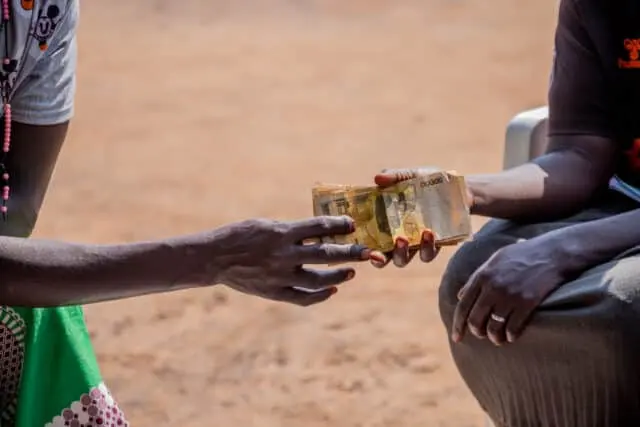Members of a Ugandan savings group exchanging money